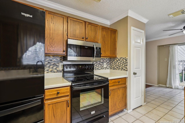 kitchen with decorative backsplash, electric range, light tile patterned floors, and a textured ceiling