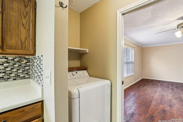 washroom with dark hardwood / wood-style floors, washer / dryer, ornamental molding, and a textured ceiling