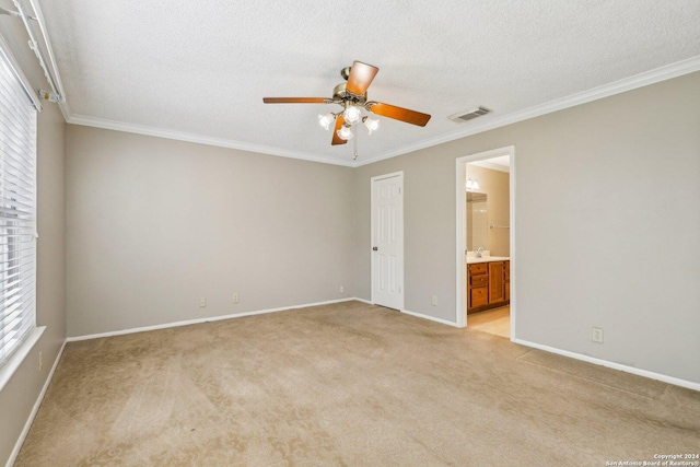 carpeted empty room featuring a textured ceiling, ceiling fan, and crown molding