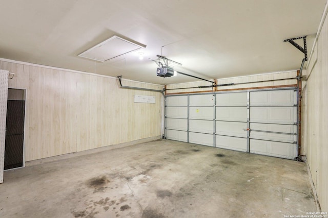 garage with wood walls and a garage door opener