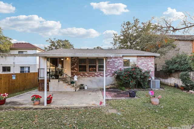 view of front facade with a patio area, a front lawn, and central AC unit