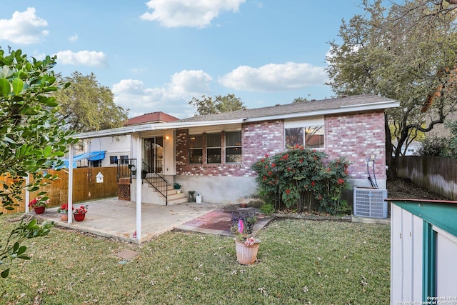 view of front facade with central AC unit, a patio area, and a front lawn