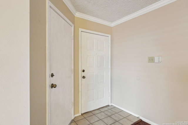 entryway with light tile patterned floors, a textured ceiling, and ornamental molding