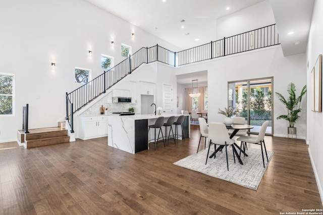 dining space featuring a high ceiling, dark hardwood / wood-style floors, and sink