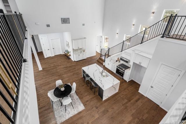 living room featuring dark hardwood / wood-style flooring, sink, and a towering ceiling