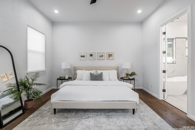 bedroom featuring ensuite bath, dark wood-type flooring, and multiple windows