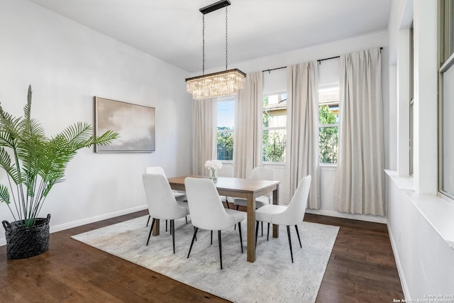 dining area with dark hardwood / wood-style floors and an inviting chandelier