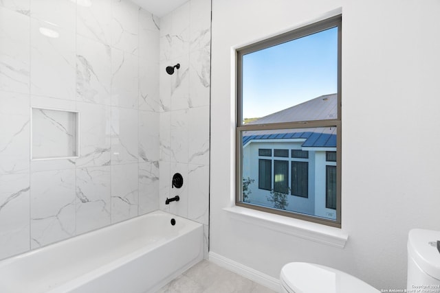 bathroom with tiled shower / bath combo and toilet