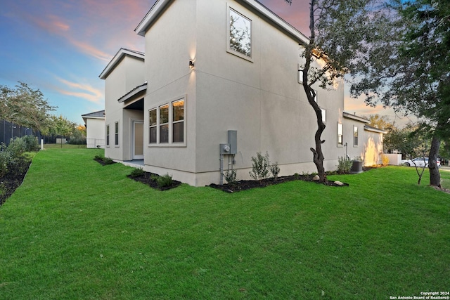 property exterior at dusk with a yard