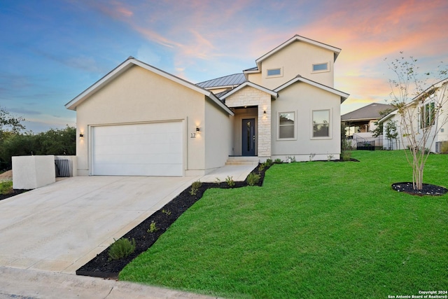 front of property featuring a lawn and a garage