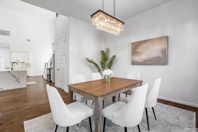 dining space with a notable chandelier, dark hardwood / wood-style flooring, and sink