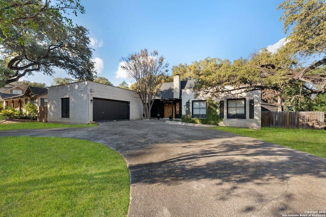 view of front of property with a garage and a front lawn