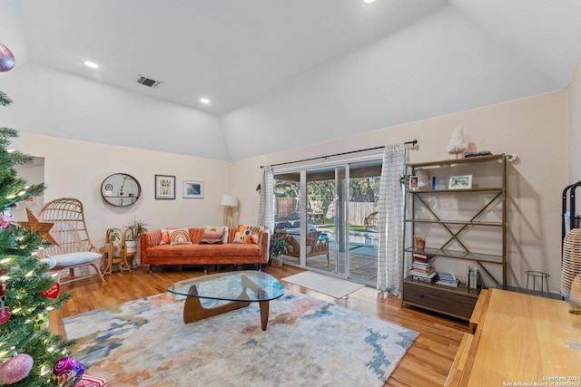 living room with vaulted ceiling and light wood-type flooring