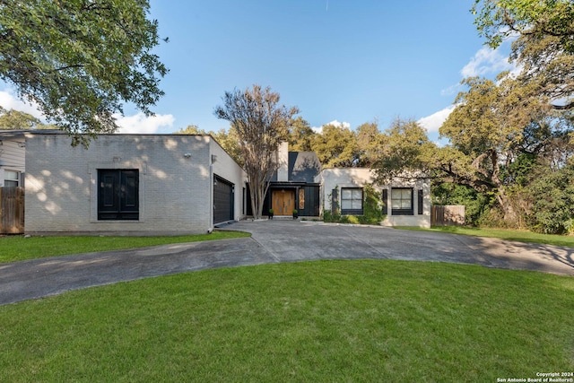 view of front of property with a front yard and a garage