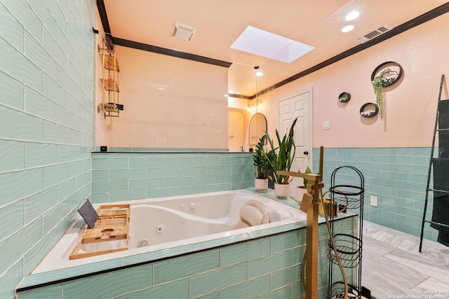 bathroom with a skylight, crown molding, and a relaxing tiled tub