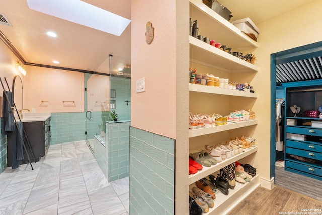 bathroom featuring crown molding, a shower with door, vanity, and hardwood / wood-style floors