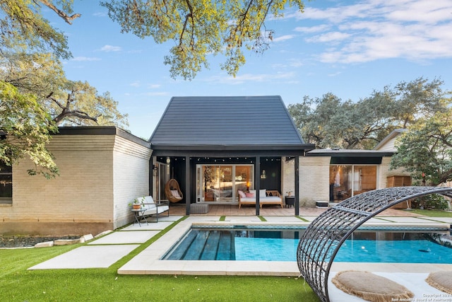 rear view of house featuring an outdoor living space and an outbuilding