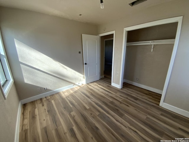 unfurnished bedroom with hardwood / wood-style flooring and a closet