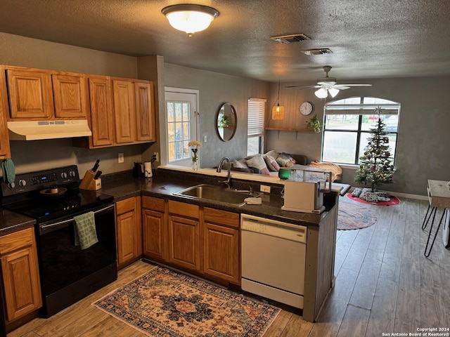 kitchen featuring kitchen peninsula, white dishwasher, ceiling fan, sink, and black / electric stove