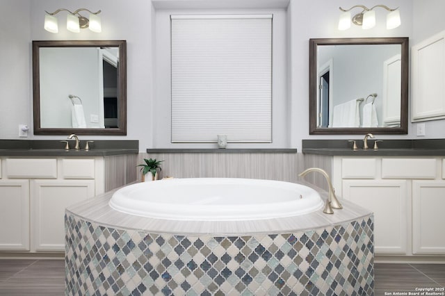 bathroom featuring tiled tub, tile patterned floors, and vanity