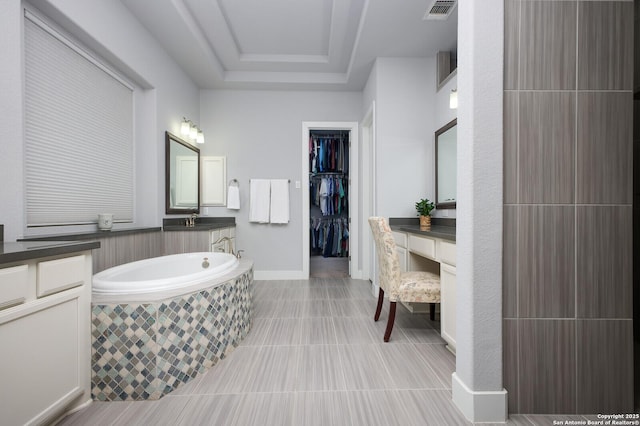 bathroom with vanity, tile patterned floors, and a relaxing tiled tub