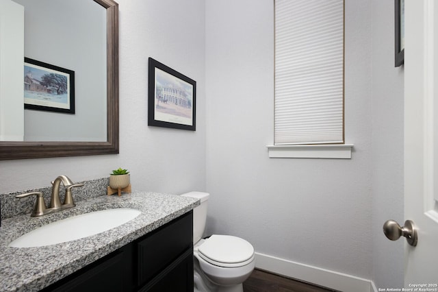 bathroom with toilet, wood-type flooring, and vanity