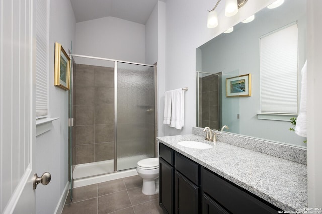 bathroom featuring toilet, a shower with door, vanity, and tile patterned flooring