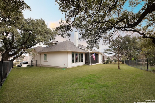 back house at dusk with a lawn