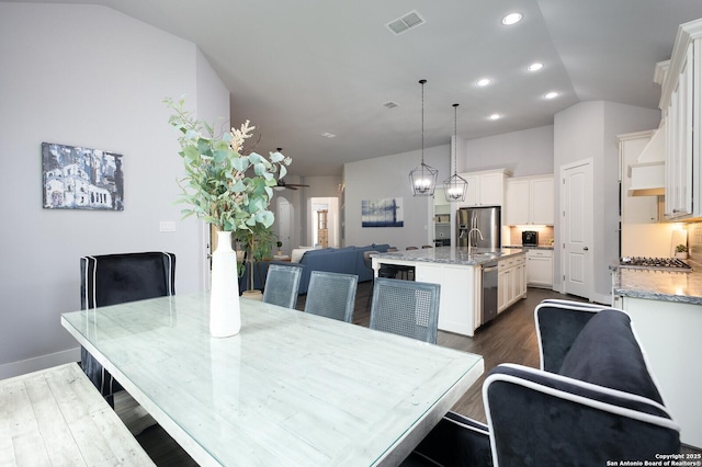 dining room with lofted ceiling, dark hardwood / wood-style floors, and sink