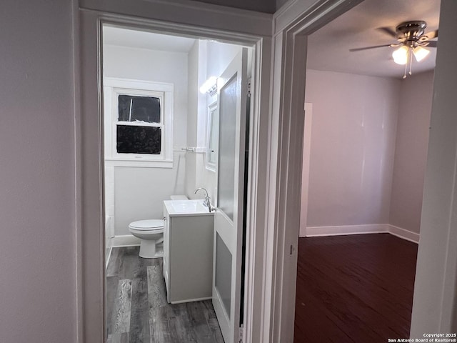 bathroom featuring ceiling fan, vanity, toilet, and hardwood / wood-style floors