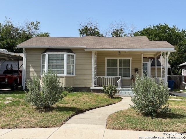 bungalow-style home with covered porch and a front yard