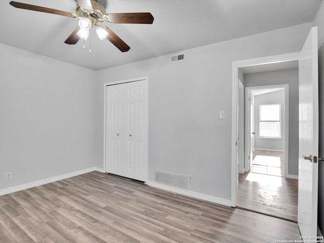 unfurnished bedroom featuring ceiling fan, a closet, and light hardwood / wood-style flooring