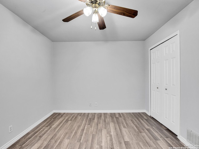 unfurnished bedroom with ceiling fan, light hardwood / wood-style flooring, and a closet