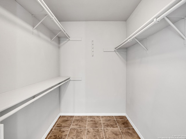 walk in closet featuring dark tile patterned flooring