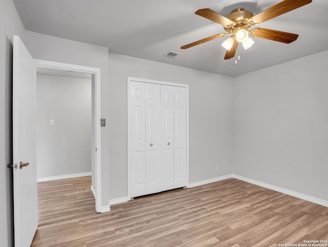 unfurnished bedroom with a closet, light hardwood / wood-style flooring, and ceiling fan