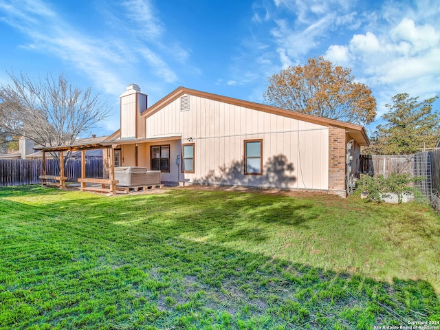 back of house with a yard and a hot tub