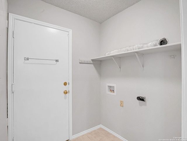 laundry room featuring electric dryer hookup, light tile patterned flooring, a textured ceiling, and hookup for a washing machine