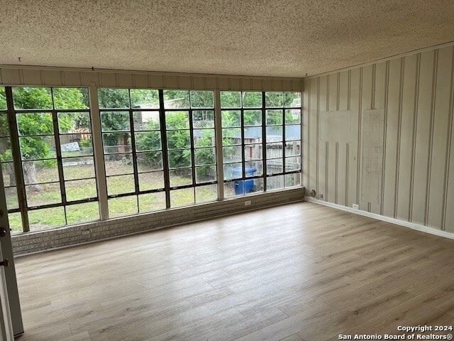 empty room with hardwood / wood-style floors and a textured ceiling