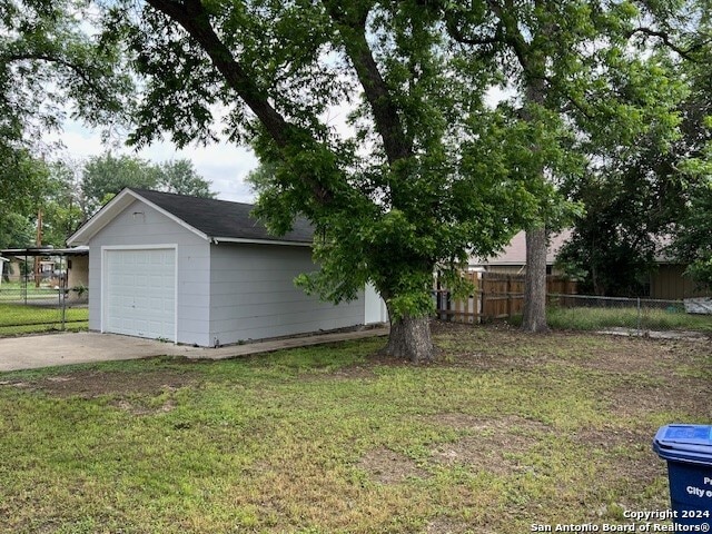 view of side of home featuring an outbuilding, a garage, and a lawn