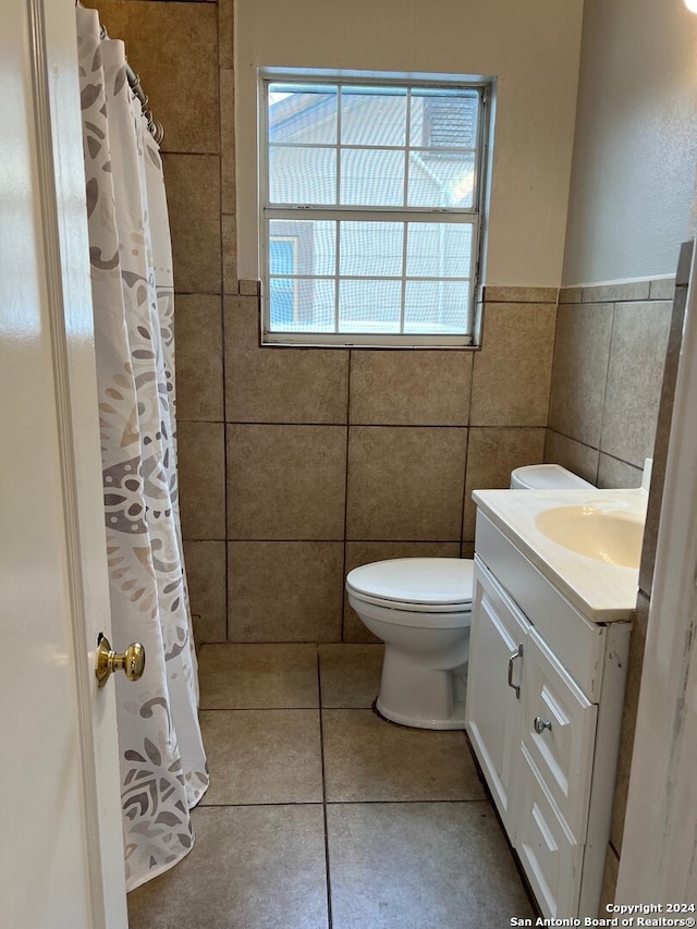 bathroom with tile patterned flooring, vanity, tile walls, and toilet