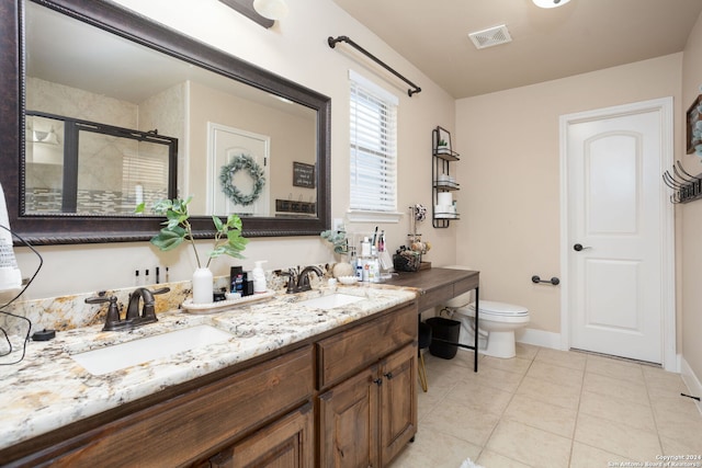 bathroom featuring tile patterned floors, toilet, vanity, and walk in shower