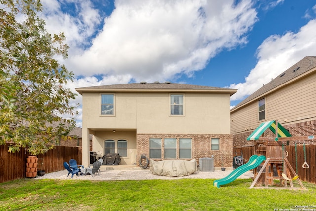 back of house with a yard, a playground, cooling unit, and a patio area