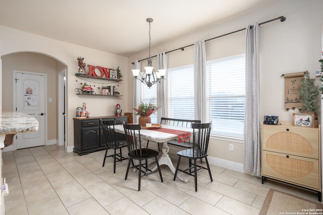 tiled dining area featuring a notable chandelier