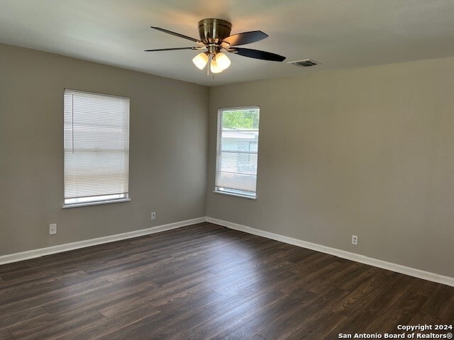 unfurnished room with ceiling fan and dark hardwood / wood-style flooring