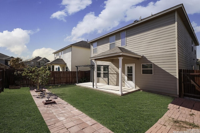 rear view of property featuring a pergola, a yard, and a patio area