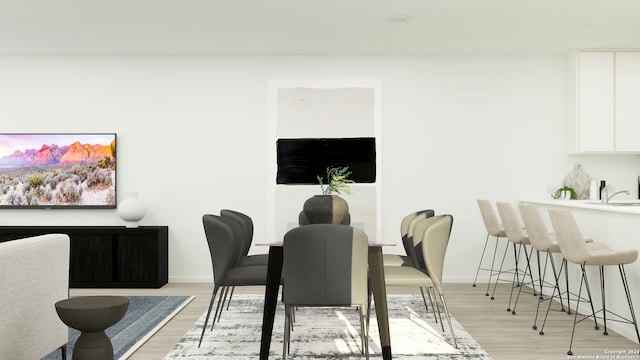 dining space with light hardwood / wood-style flooring and sink