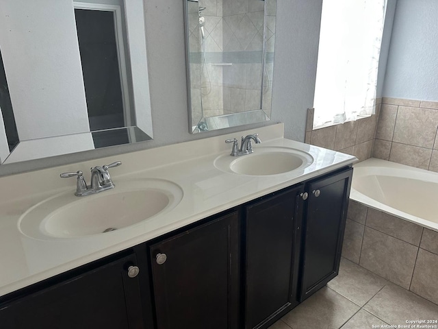 bathroom with vanity, a relaxing tiled tub, and tile patterned floors