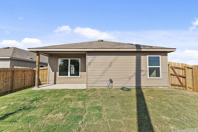 rear view of house featuring a yard and a patio area