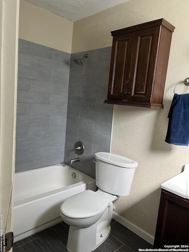 bathroom with toilet and tiled shower / bath