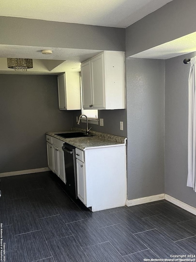 kitchen featuring dishwasher, white cabinetry, and sink